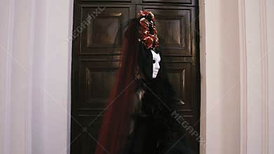 Halloween girl in witch sitting on a bench in the city park forest. Mystery and horror concept.