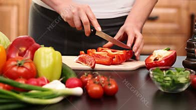 Woman hands slicing red bell pepper for a vegetables salad
