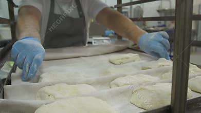 Making Croissant Cookies with Jam and butter. Series. Cutting dough with cutter into triangles. baker in modern bakery