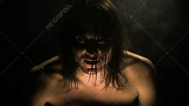 In a dark room, a devil settles into a man