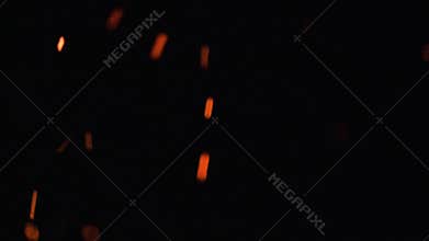 Ultra slow motion shot of fire flames and glowing ashes on black background