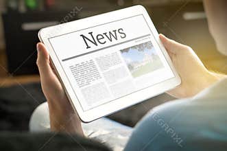 Man reading the news on tablet at home.