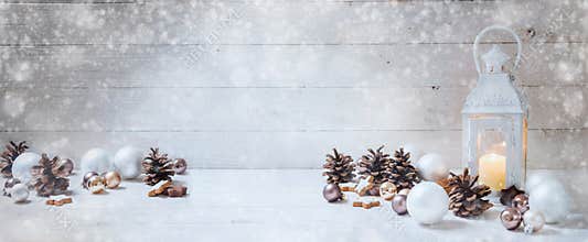 Wide christmas background with a candle light lantern, baubles,