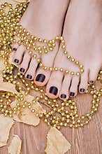 Female feet with dark purple pedicure.