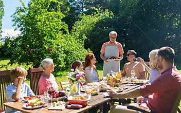 Happy family having dinner or summer garden party