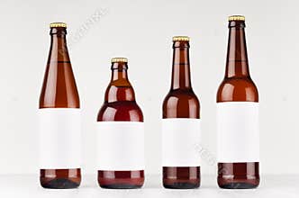 Brown beer bottles collection different type with blank white label on white wooden board, mock up.