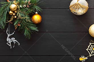Xmas balls on merry Christmas tree, happy new year card decoration on black wooden background, top view, copy space