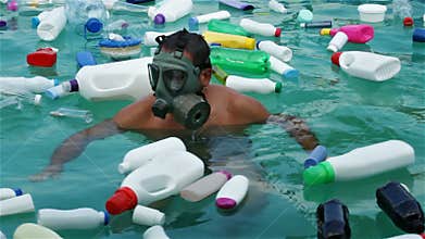 Man swim in plastic polluted water using protecting mask