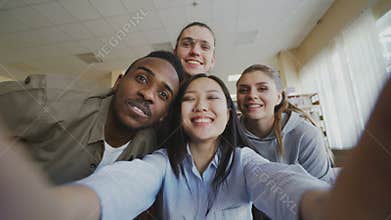 Point of view of asian girl holding smartphone taking selfie photos with cheerful classmates and have fun at university