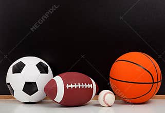 Assorted sports balls with a chalk board