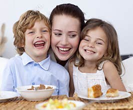 Children having breakfast with their mother