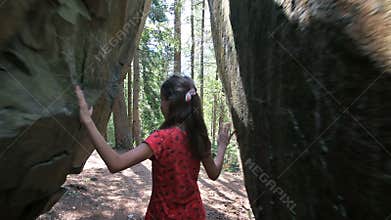 Girl exploring forest on sunny day in secret passway