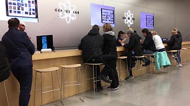 Motion of people having some service at genius bar inside Apple store