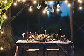 Decorated outdoor wedding table with flowers in rustic style