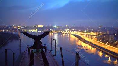 Courageous athlete making headstand on the edge of bridge, adrenaline and sports