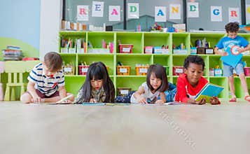 Group of diversity kid lay down on floor and reading tale book i