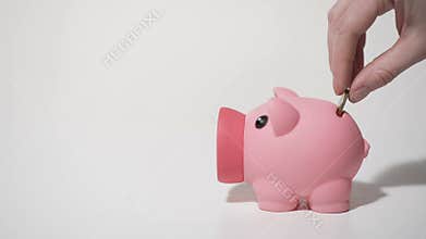 Human hand putting penny coin in piggy bank, saving money on personal account