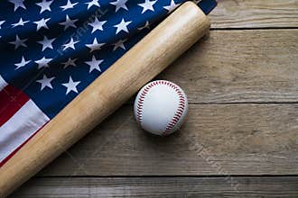 baseball and baseball bat with American flag on wooden table background