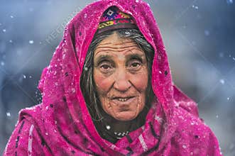 Old woman in the middle of snow waiting animals to return from pasture.