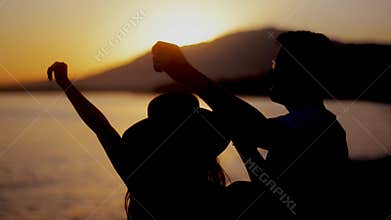 Happy couple dancing on beach enjoying honeymoon in nature at sunset . Couple enjoying a romantic sunset evening together