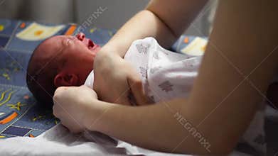 Asian newborn baby smiling when swaddle her body with Diapers after taken shower.