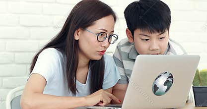 Happy asian family Mother and son watching and laugh while looking computer laptop.