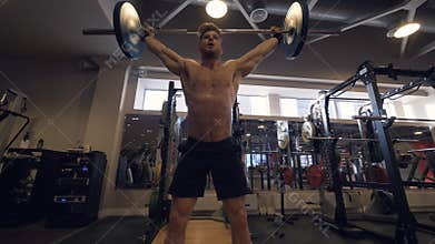 Man bodybuilder lifting weight barbell on powerlifting training in sport club