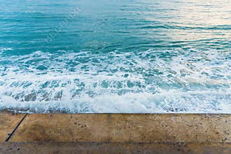 Sea water wave splashing on embankment, forming a spray.Exotic w