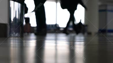 People walking through an airport terminal with suitcases, bags and baggage