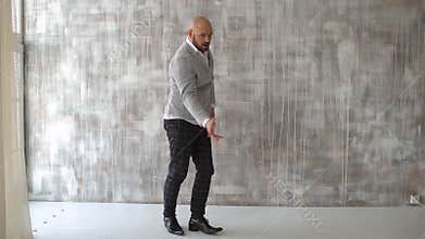 Man dancing on gray background. Crazy happy businessman dancing wearing a suit celebrating achievement. Portrait of