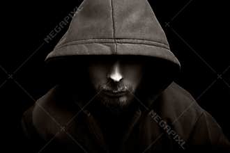 Scary evil man with hood in the dark