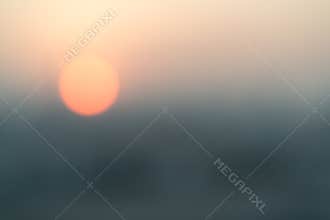 Blur abstract background of red sun going down in the city. Sunset scene or nature concept