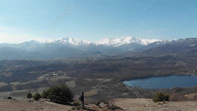 Aerial: woman hiking on the mountains, backpacker walking outdoors panoramic view, inspiring travel and freedom, drone flight reve