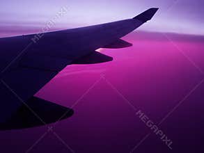 Air travel plane wing wih violet sky