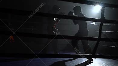 Guys preparing for a kickboxing competition. Silhouette. Slow motion