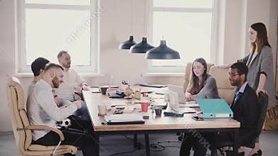 Caucasian female leader motivates happy multiethnic colleagues at healthy office business team meeting slow motion.