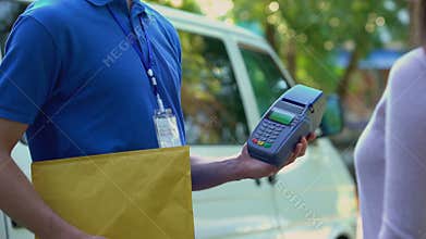 Female paying for parcel delivery via smartphone application contactless payment