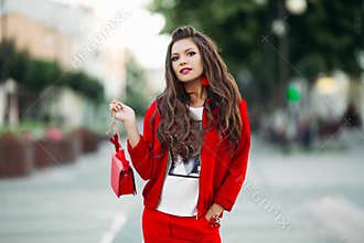 Fashionable girl in red sport chic suit with crossbody bag in th