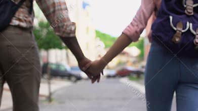 Happy couple walking in city holding hands, travelling together, outdoor date