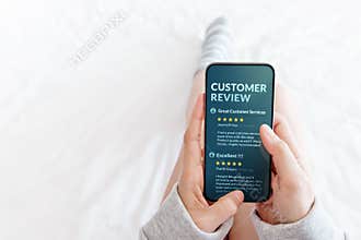 Customer Experience Concept. Woman lying on Bed to Reading Online Review via Smartphone before Buying Products and Services, More