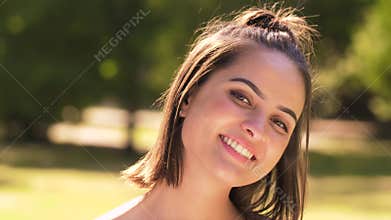 Portrait of happy young woman in summer park
