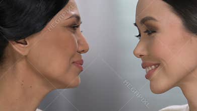 Elderly mom looking at adult daughter, unconditional love and care, motherhood