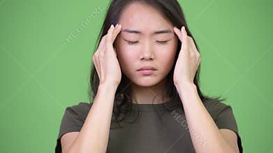 Young stressed Asian woman having headache
