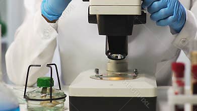 Lab assistant observing blood under microscope, genetic research, dna testing