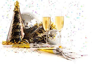 Champagne glasses with festive party hats on white
