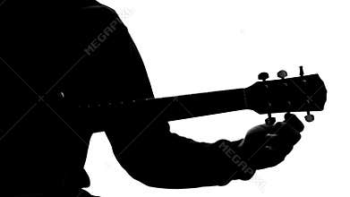 Silhouette of male musician tuning up acoustic guitar, young composer, hobby