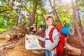 Little boy with treasure map in the forest game