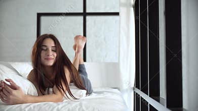 Happy Woman Lying On Comfortable Bed At Light Bedroom