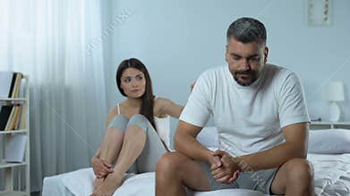 Man suffering problems with masculine health, wife supporting him, impotence