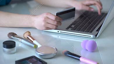 Make-up artist ordering new cosmetics online, typing data of her credit card